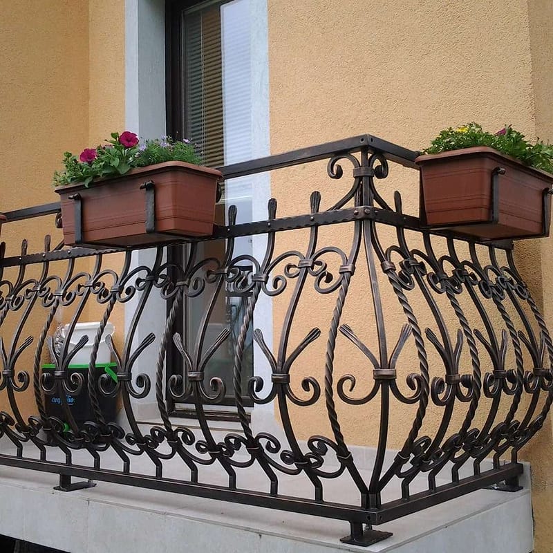 Kovinska balkonska ograja s kovanimi okraski in cvetličnimi koriti
